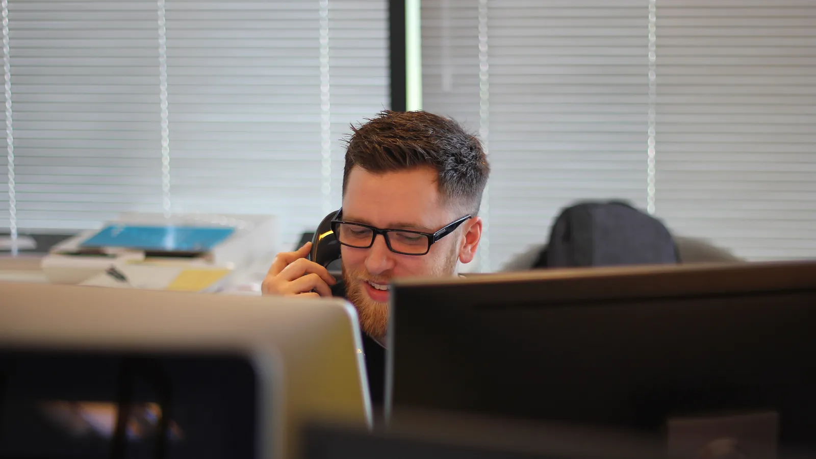 Service technician on the phone in front of a computer screen